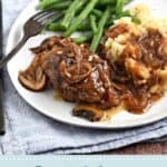 Mushroom gravy topped hamburger steak and mashed potatoes with green beans, with blue title graphic across the bottom.