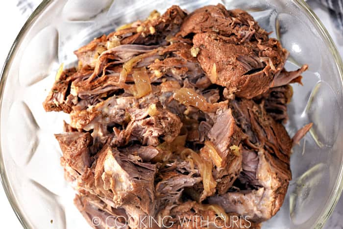 Shredded pork in a large glass bowl. 