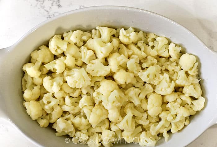 Steamed cauliflower in a white baking dish. 