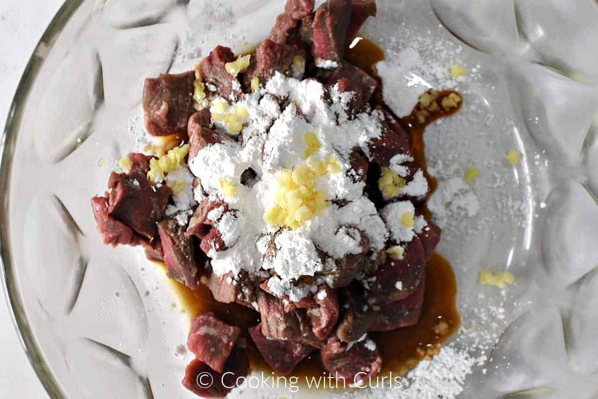 Strips of beef, cornstarch, minced garlic, and sesame oil in a large bowl. 