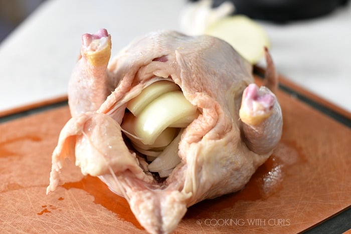 Stuff the whole chicken with onion wedges and garlic cookingwithcurls.com