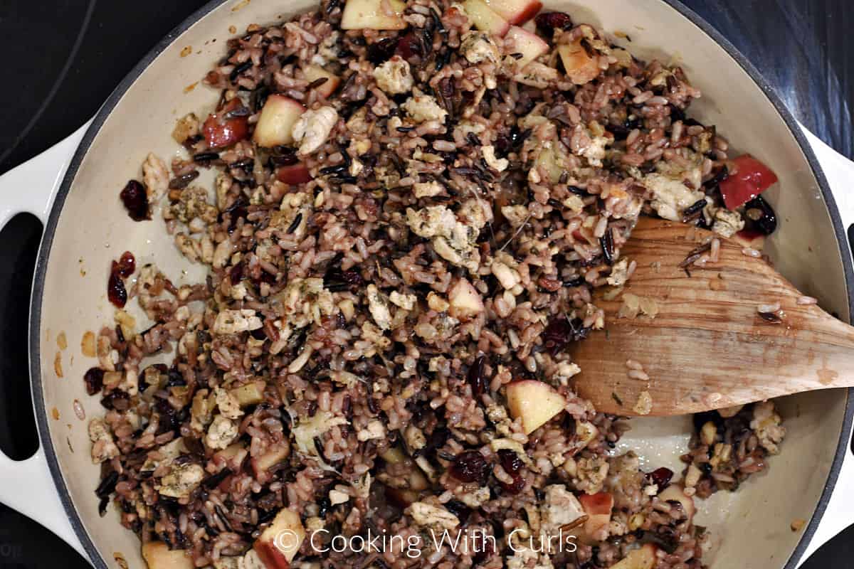 Stuffing mixture with wooden turner stirring in the cheese. 