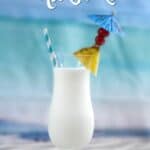 Creamy Pina Colada Milkshake in a hurricane glass that is garnished with a pineapple wedge, cherries and a blue paper umbrealla.