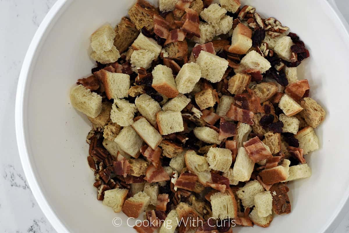 Toasted bread cubes, bacon, pecans, and dried cranberries in a very large bowl. 