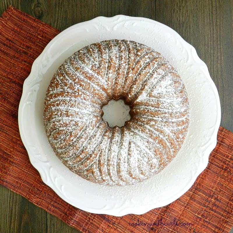 Traditional Moroccan Orange Cake on a large white plate sitting on an orange tweed napkin