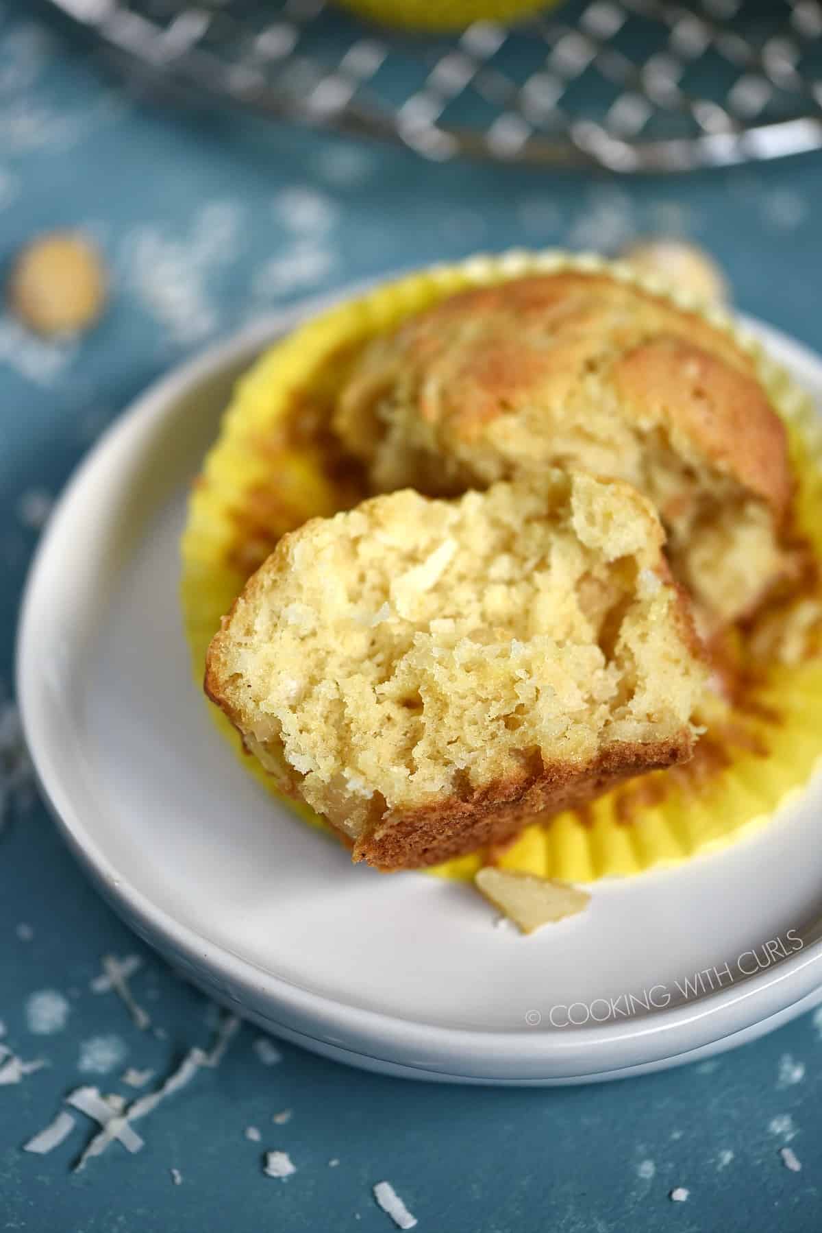 A Pina Colada Muffin split in half laying on a small white plate.