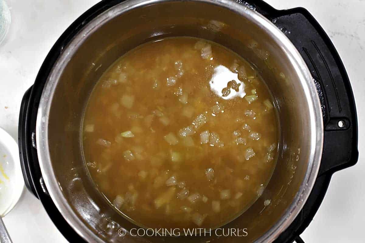 Vegetable stock added to the vegetables in the pressure cooker. 