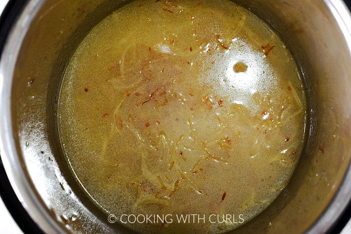 Water stirred into the rice, onion, and garlic mixture. 