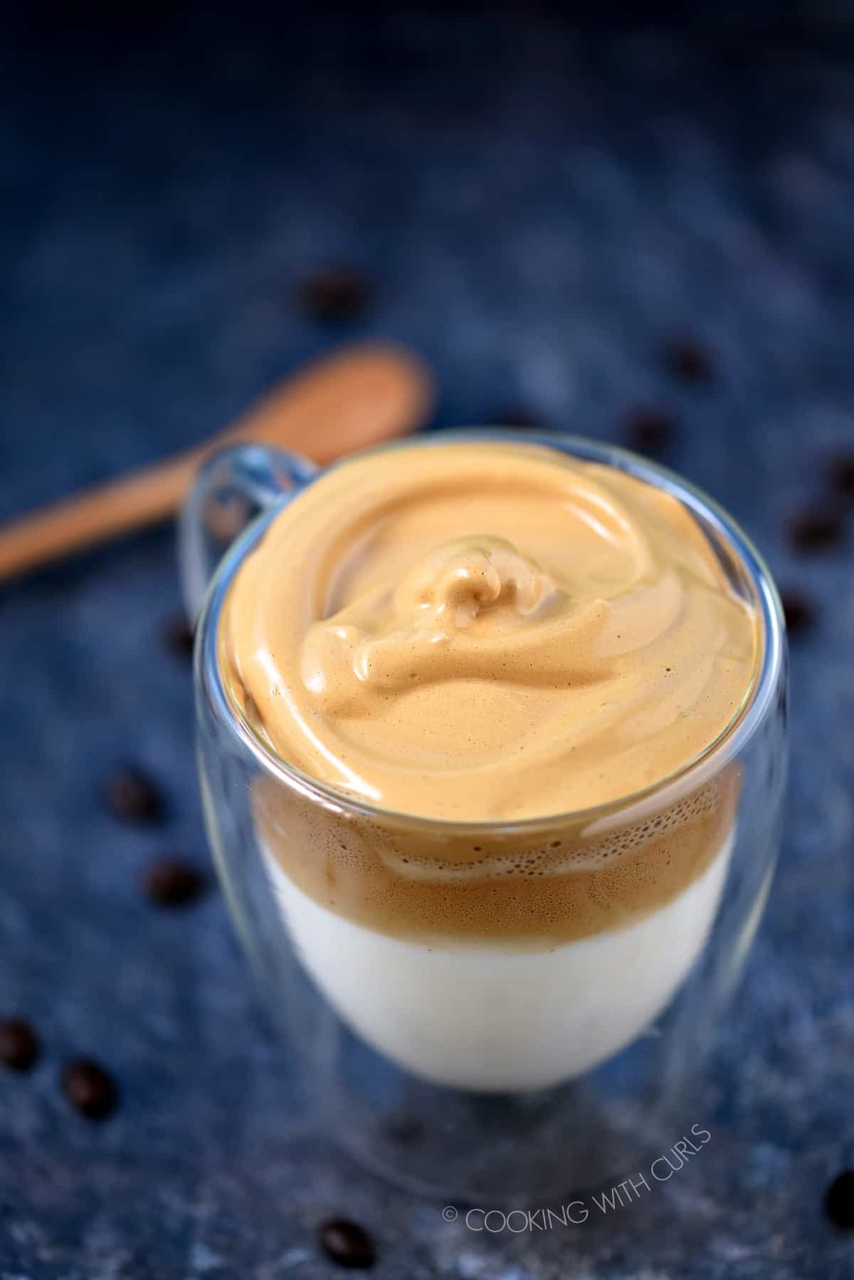 Looking down on a clear glass mug filled with Whipped Dalgona Coffee.