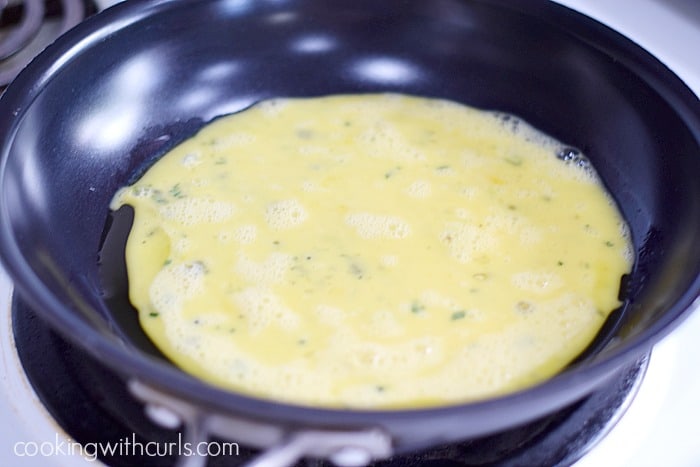 scrambled eggs poured into a non-stick skillet.