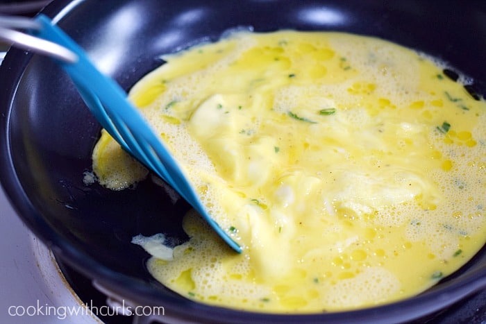 Cooking scrambled eggs in a skillet using a spatula to move the cooked part and allow the runny part to take it's place.