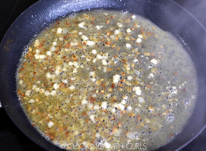 Wine and lemon juice simmering with the onions in a skillet. 